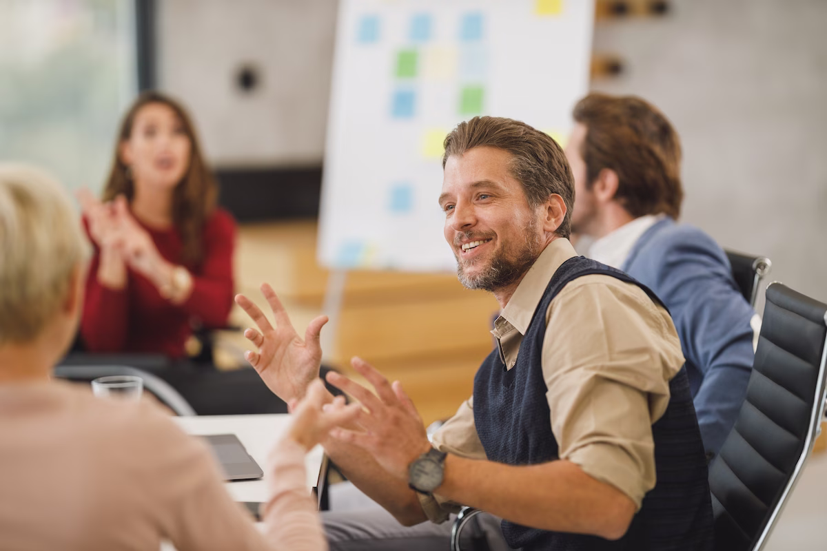 Colleagues in a meeting room discussing a deal